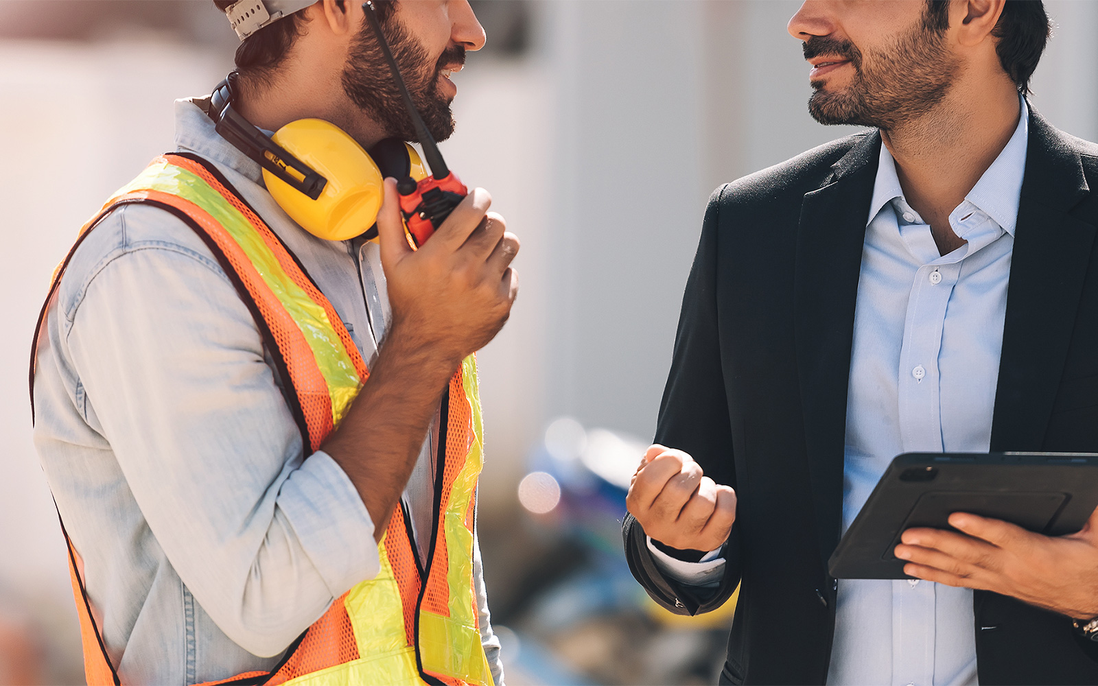 Site staff in high-vis and project manger in a suit talking to each other