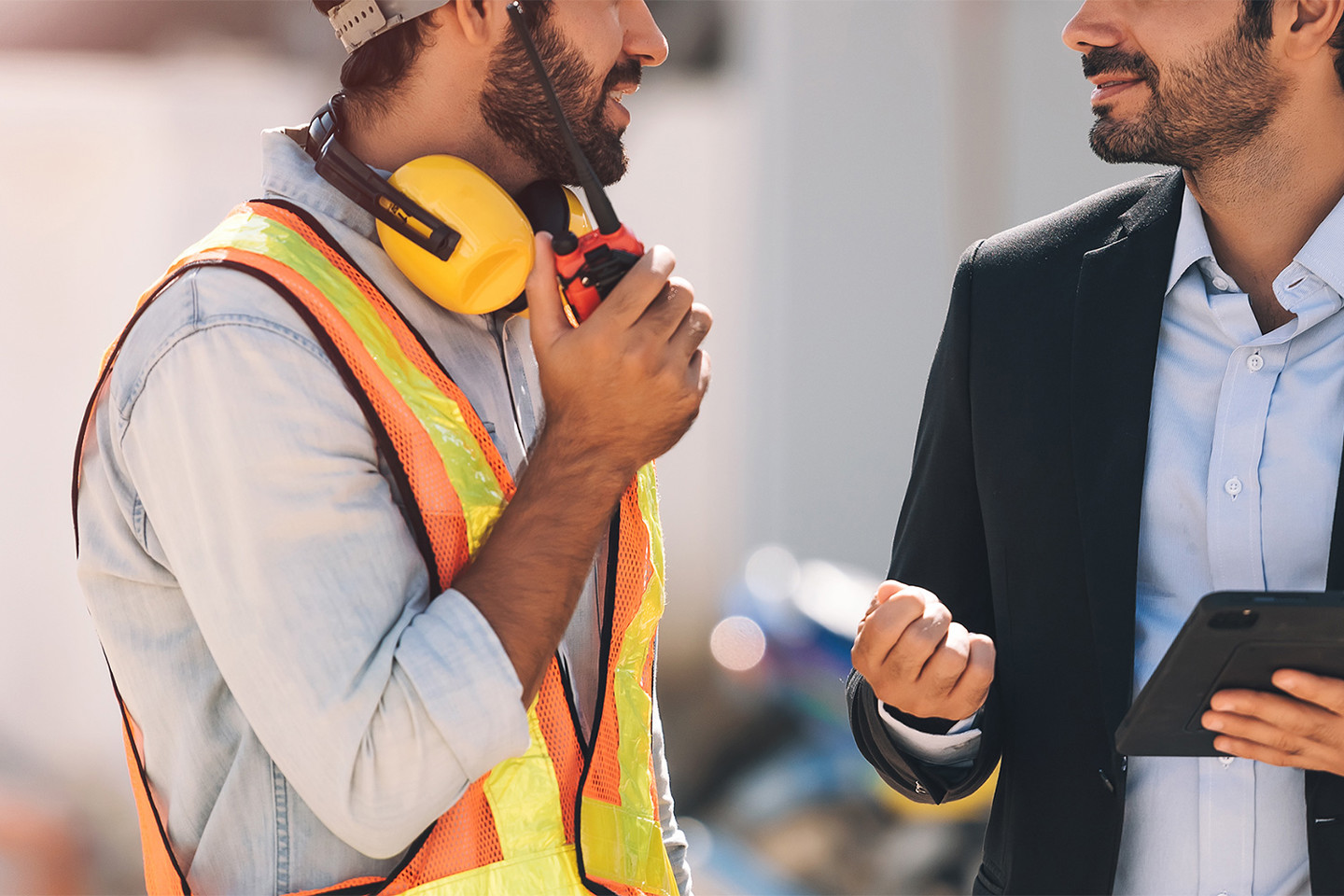 Site staff in hi-vis talking to project manager in suit