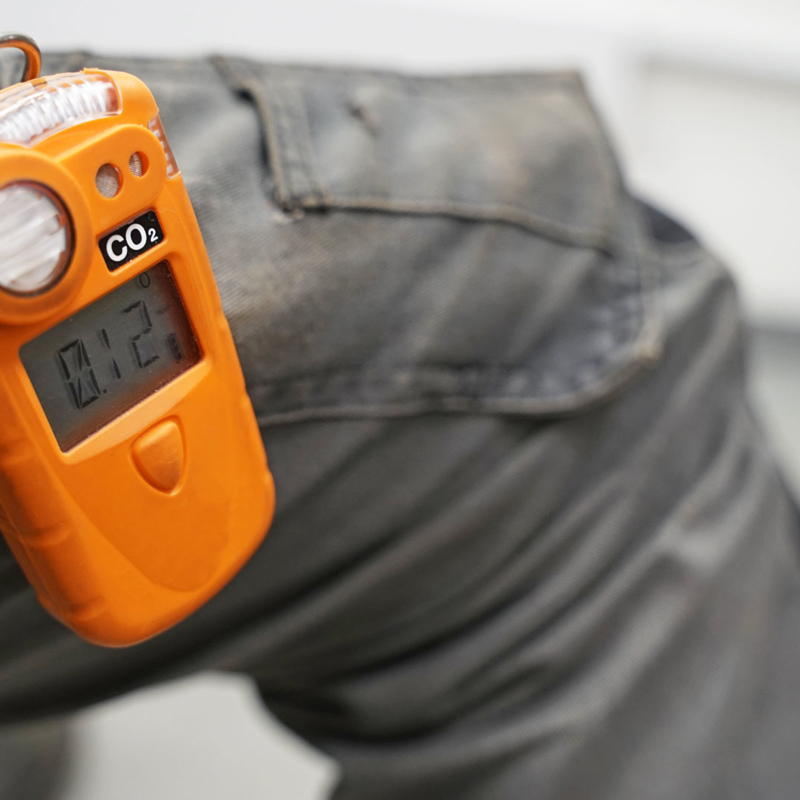 Co2 safety personal portable gas monitor and detector attached to worker's trousers
