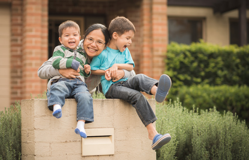 Mother with her 2 young children outside home from new social and affordable housing