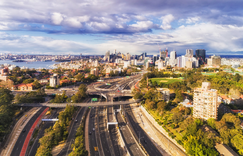 Aerial shot of West Harbour motorway with vehicles driving and the city in the background