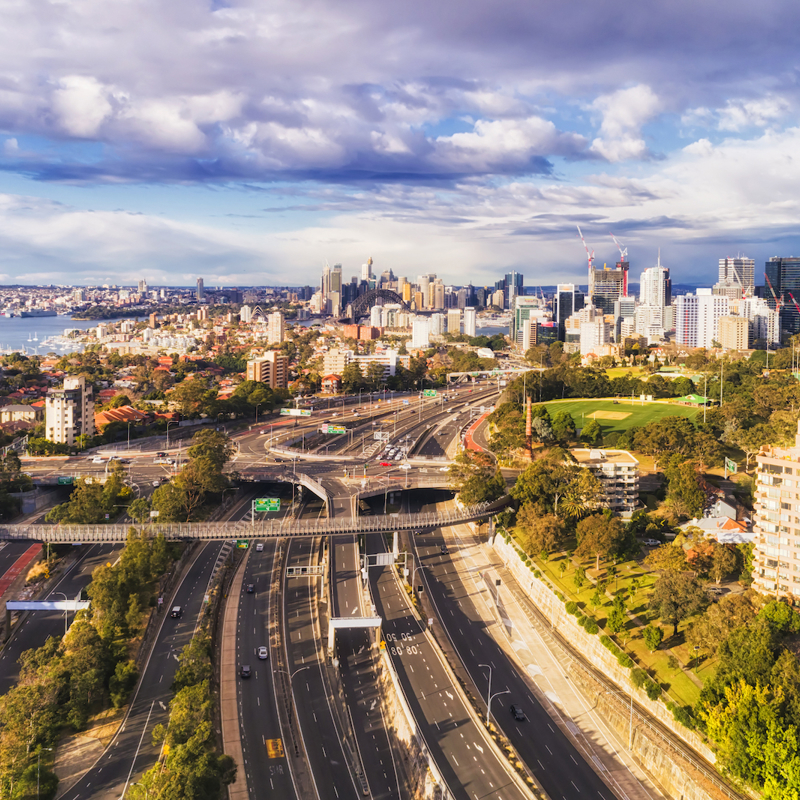 Aerial shot of West Harbour motorway with vehicles driving and the city in the background