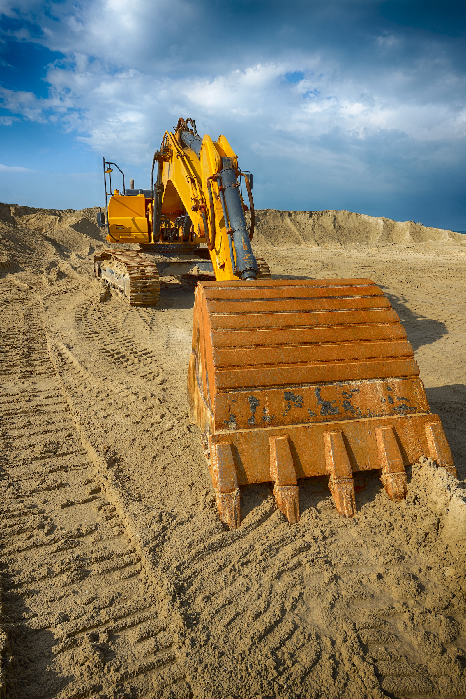 Digger on sand bank being used for environmental investigation and remediation