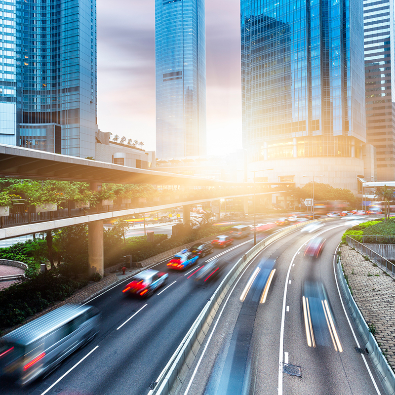Busy urban cityscape with pedestrian walkway, highway, tunnel and commercial buildings