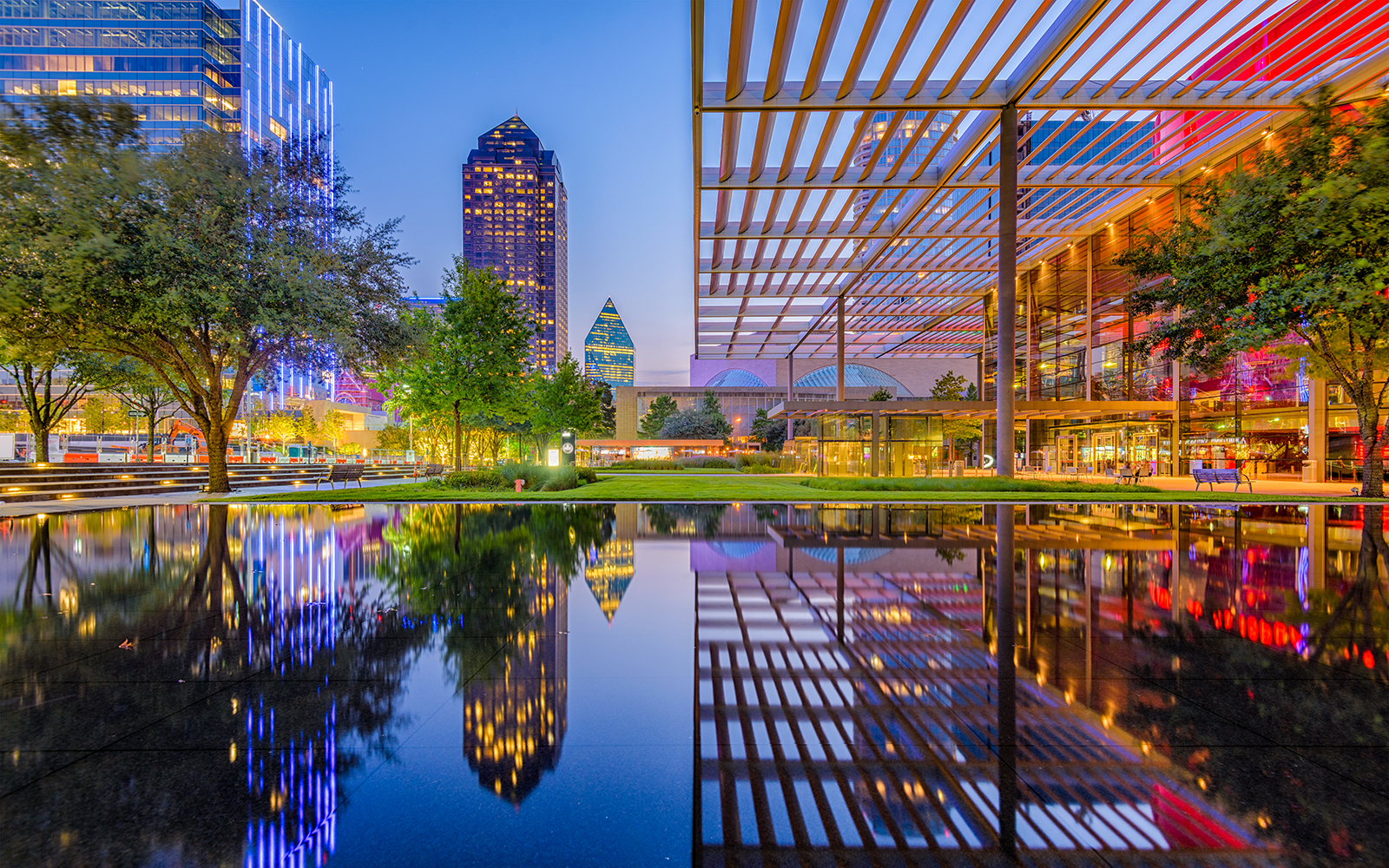 City scape of tall buildings at night built around water 