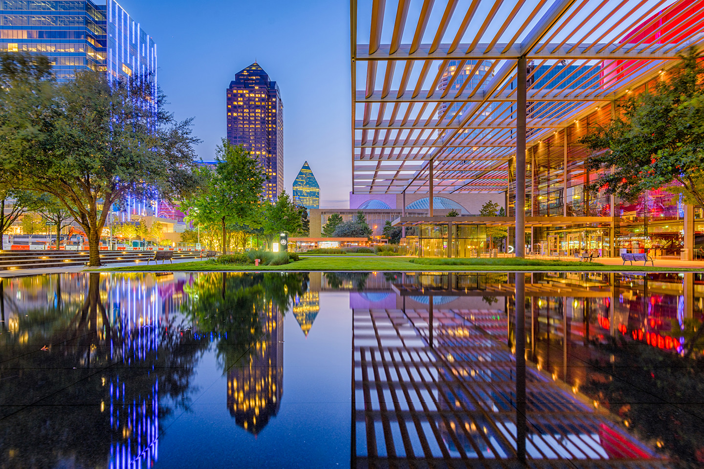 City scape of tall buildings at night built around water 