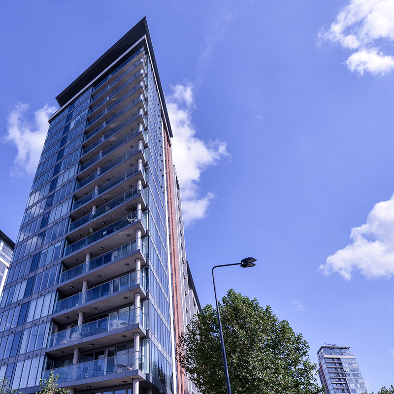 A view of high rise apartment block against blue sky