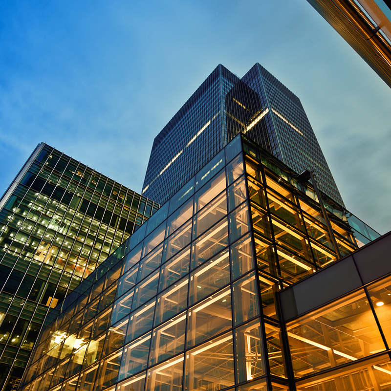 A view from the ground up of an office building lit up at night
