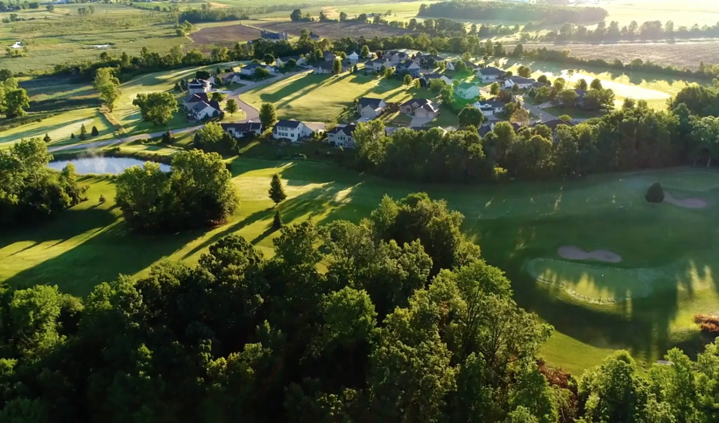 Environment landscape with small housing development, pond and golf course 