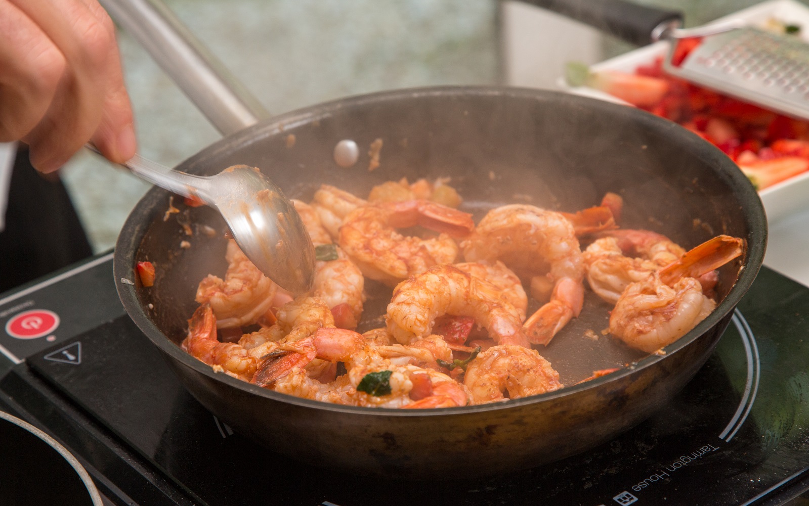 Prawns being cooked in a pan over a stove