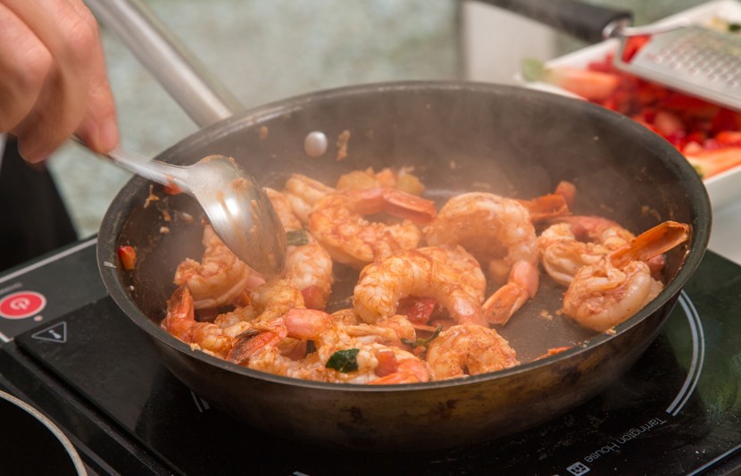 Prawns being cooked in a pan over a stove