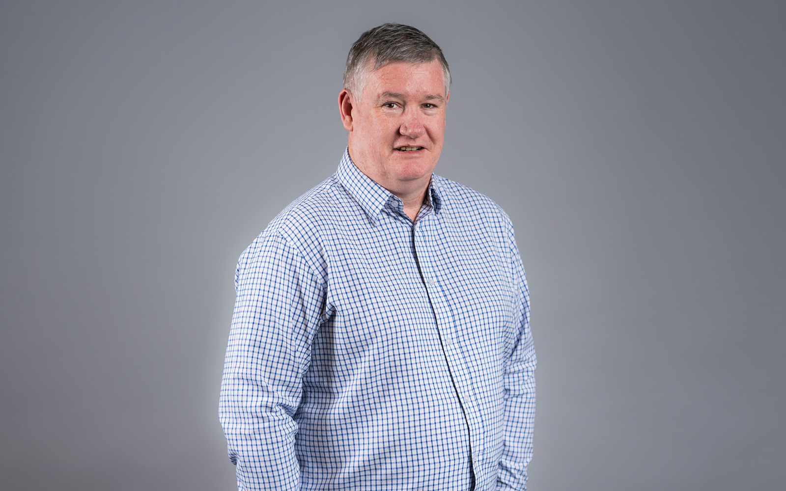 Graham Elgie, RPS General Manager - Geospatial Solutions NSW smiles at the camera wearing blue check shirt
