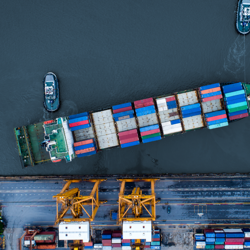 Aerial shot of a ship loaded with containers near a port