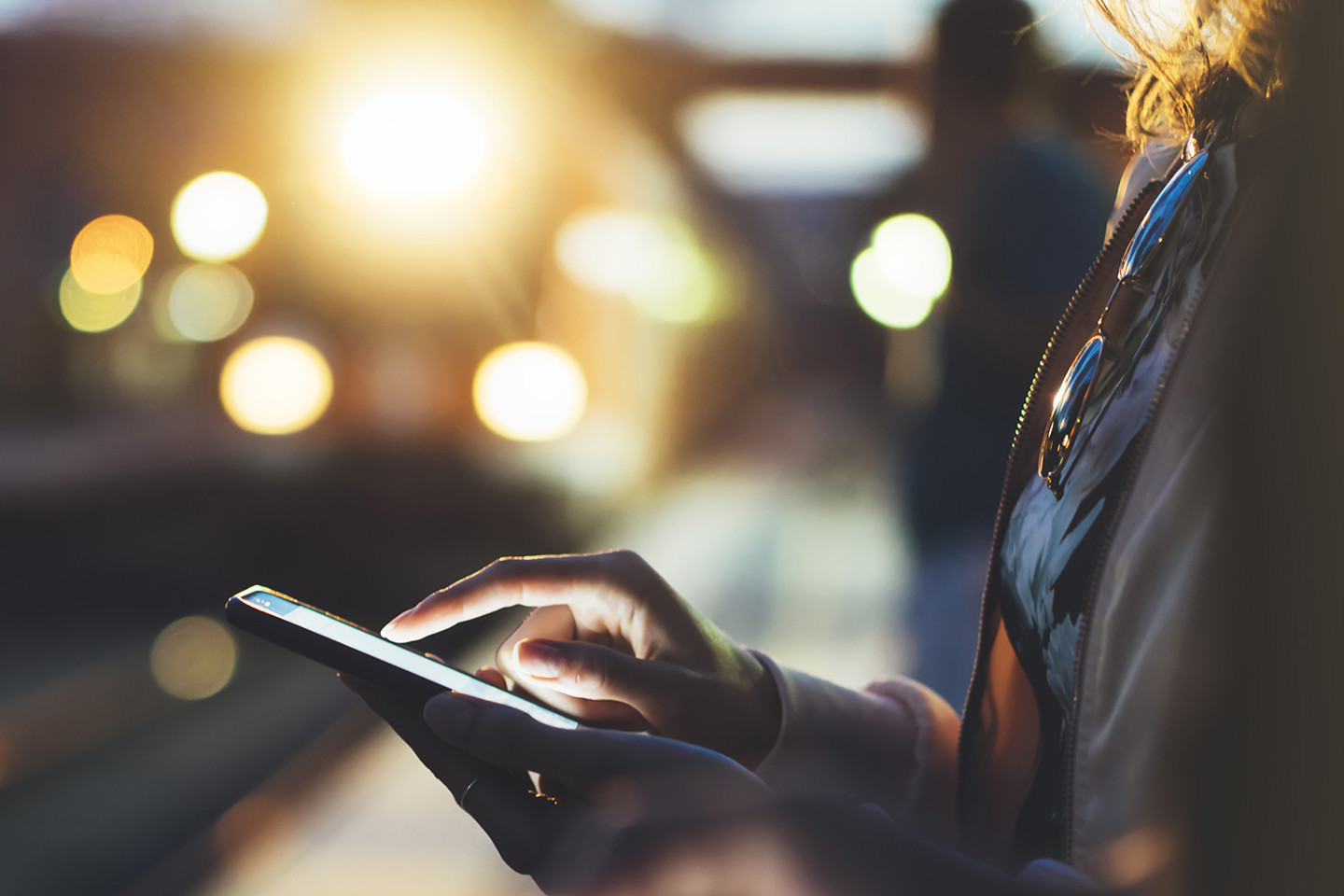 Woman using phone while waiting on railway platform