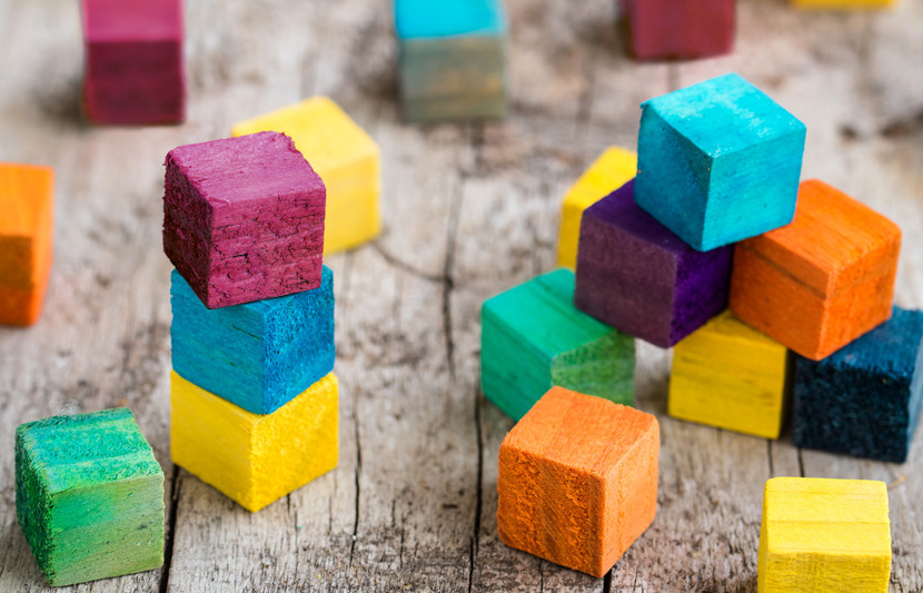Wooden stacked coloured blocks building blocks representing fast tracked infrastructure