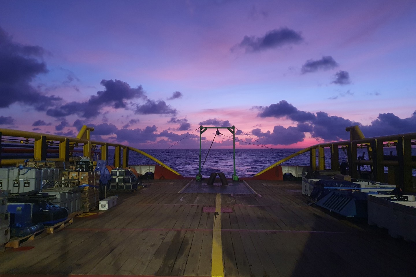 A view from the back of a boat at night looking at to the ocean