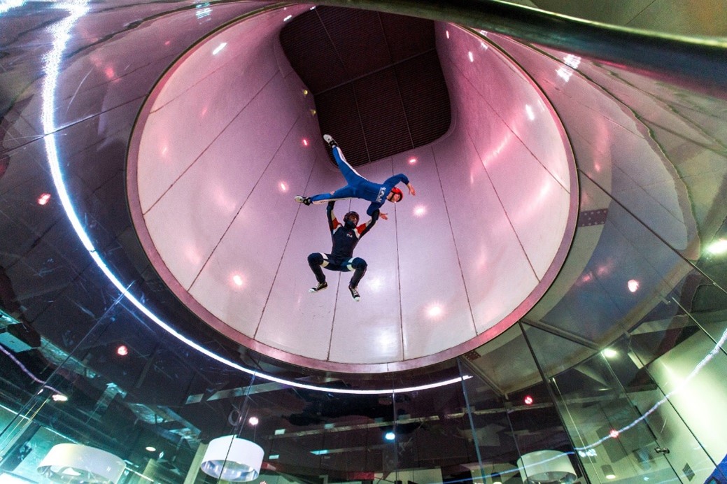 Two flyers in iFly indoor skydiving wind tunnel