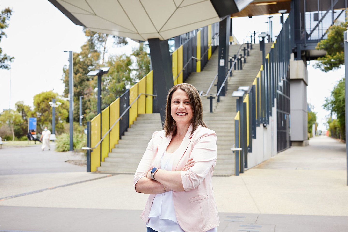 Mandi Davidson, RPS National Lead, Communications and Engagement stands outside and in front of yellow steps at the new Sunshine Train Station in Melbourne.