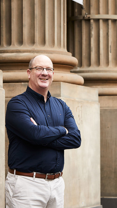 Greg Harrison, RPS  Victorian Lead for Strategy and Investment stands in front of Pillars outside the State Library of Victoria in Melbourne CBS.