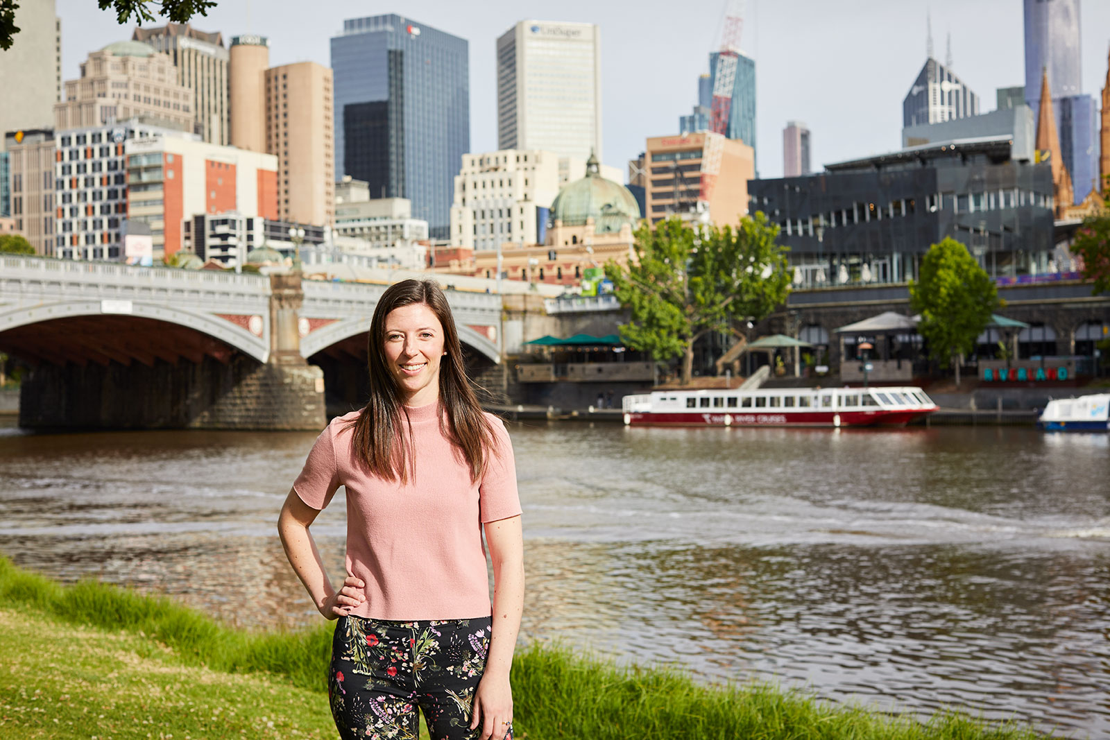 Emma Wiggan, RPS communications and engagement consultant is standing in front of the Yarra River and Princes bridge with Melbourne CBD in the background.