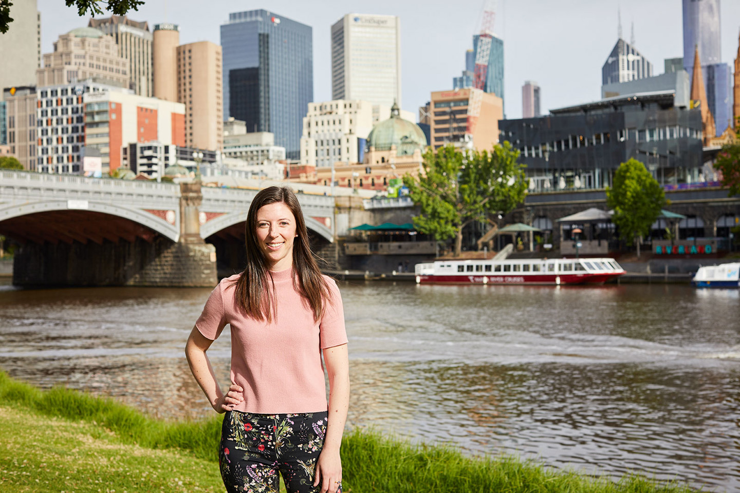 Emma Wiggan, RPS communications and engagement consultant is standing in front of the Yarra River and Princes bridge with Melbourne CBD in the background.