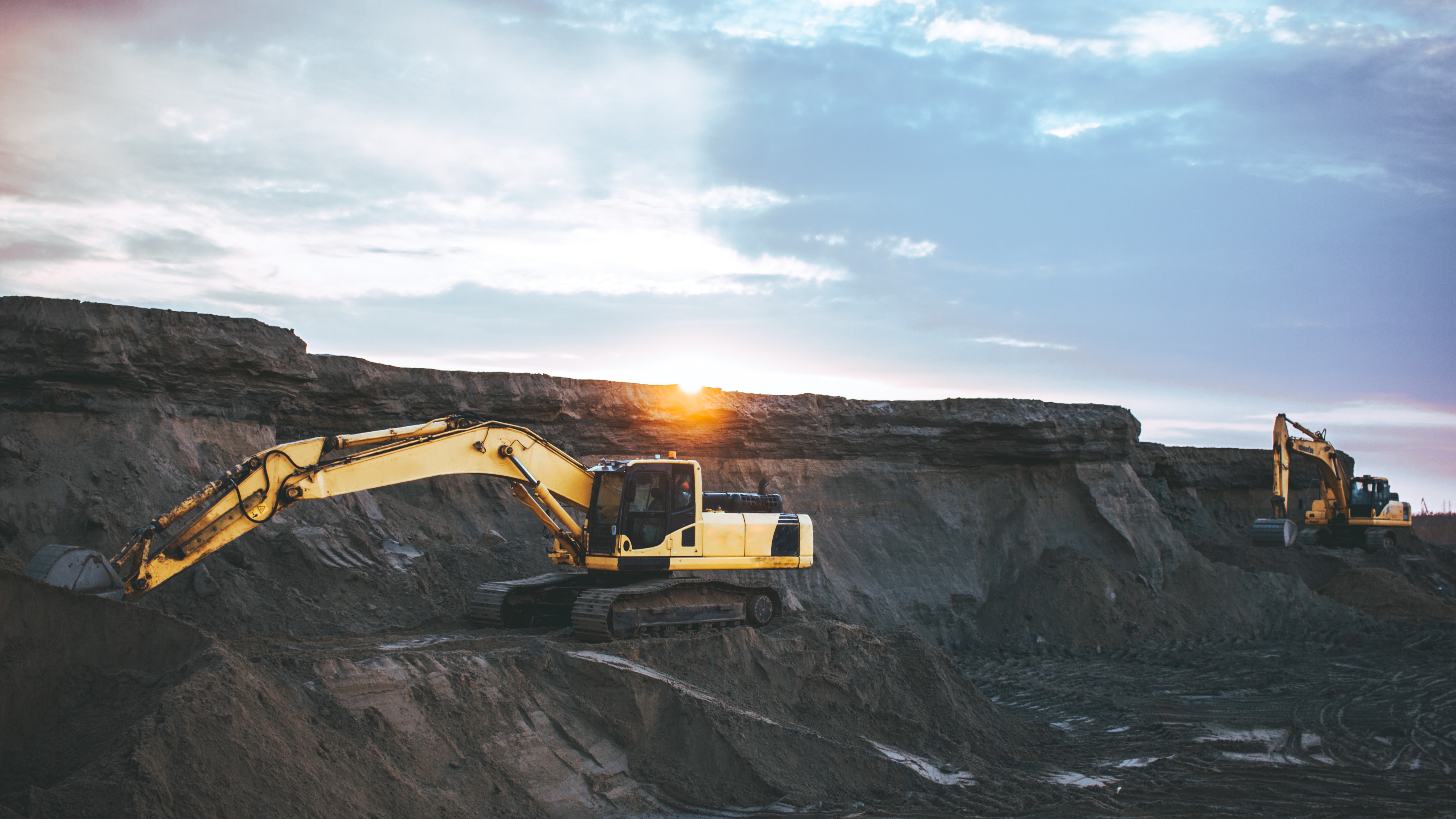 Mineral resource extraction site with yellow digger working on site
