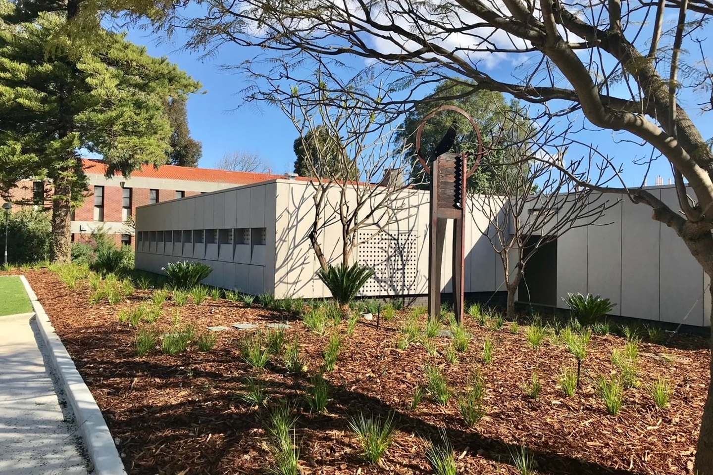 Garden with bark, trees and plants outside of Hayman Theatre