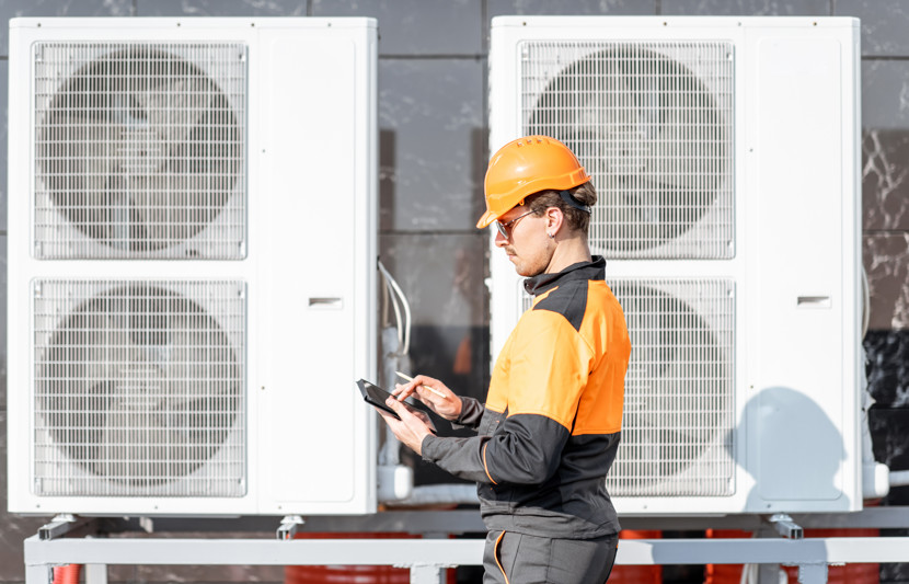 Man carrying out checks for servicing various large heat pumps 