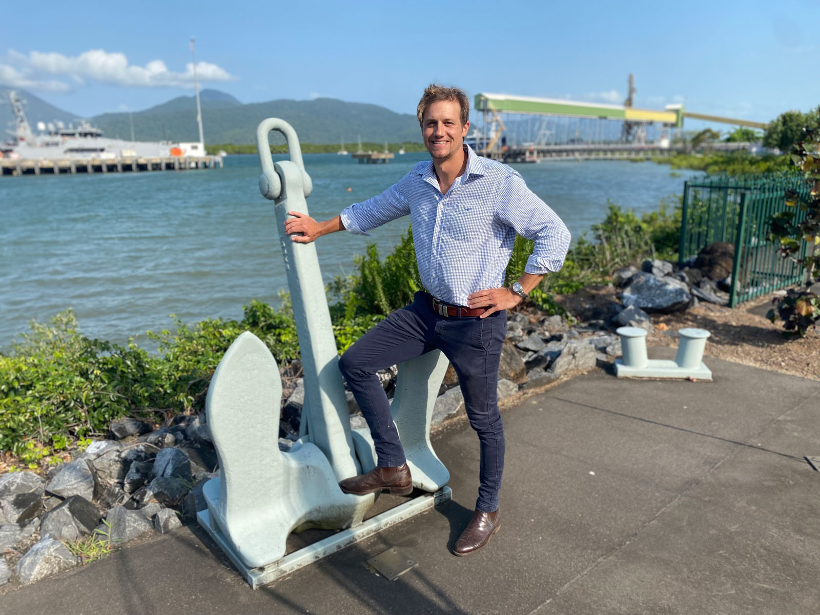 Lee Leither, RPS Project Manager stands in front of a model ship anchor overlooking a navy ship and sea
